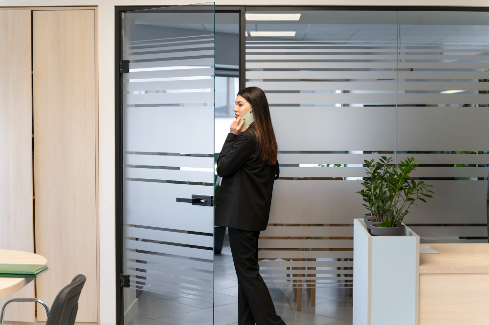 Acoustic glass door with frosted panels providing privacy in a modern office space.